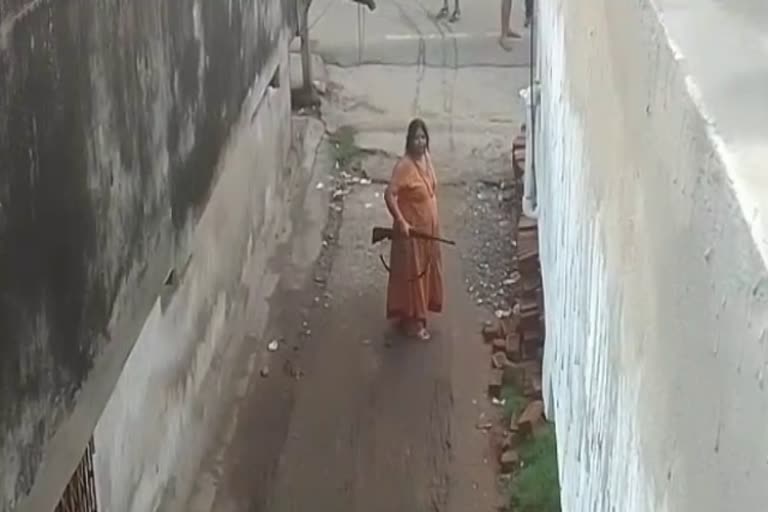 woman with rifle threatened and beat up people In Dhanbad
