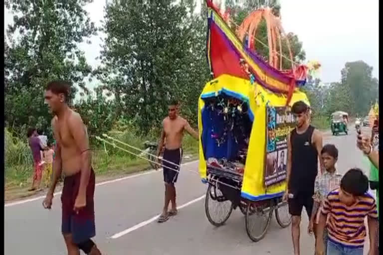 A person dragging a Kanwar by piercing metal hooks on to his body  Kanwar yathra  man dragging kanwar by piercing metal hook  uttarakand kanwar  കൻവാർ യാത്ര  വണ്ടി കെട്ടിവലിച്ച് യുവാവ്  കൻവാർ തീർത്ഥാടനം