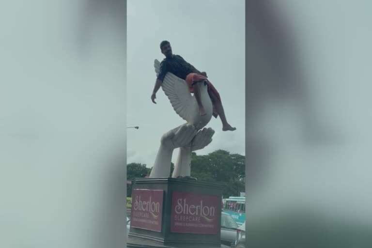 man performed on pigeon stupa at kannur  man performed on stupa  നഗര മധ്യത്തിൽ സ്‌തൂപത്തിൽ കയറി യുവാവിന്‍റെ അഭ്യാസ പ്രകടനം  circus on pigeon stupa at kannur  circus of a man on pigeon stupa at kannur  കണ്ണൂർ കെഎസ്ആർടിസി ബസ് സ്റ്റാൻഡിനു മുന്നിലെ പ്രാവ് സ്‌തൂപത്തിന് മുകളിൽ യുവാവിന്‍റെ അഭ്യാസ പ്രകടനം  കണ്ണൂർ പ്രാവ് സ്‌തൂപത്തിന് മുകളിൽ കയറി യുവാവിന്‍റെ അഭ്യാസ പ്രകടനം