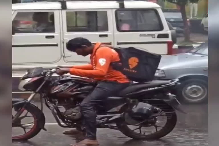 Swiggy delivery man toiling to deliver flavoursome food in deluge  Swiggy delivery boy working in rain  Swiggy delivery boy working in rain viral video  viral video of Swiggy delivery boy working in rain vijayawada  ജീവിക്കാന്‍ മഴ നനഞ്ഞ് ജോലി ചെയ്യുന്ന സ്വിഗ്ഗി ജീവനക്കാരന്‍റെ ദൃശ്യം  വിജയവാഡയിലെ വൈറല്‍ സ്വിഗ്ഗി ജീവനക്കാന്‍  മഴയത്ത് ട്രാഫിക് സിഗ്നല്‍ കാത്തു നില്‍ക്കുന്ന സ്വിഗ്ഗി ഡെലിവറി ജീവനക്കാരന്‍റെ വൈറല്‍ വീഡിയോ