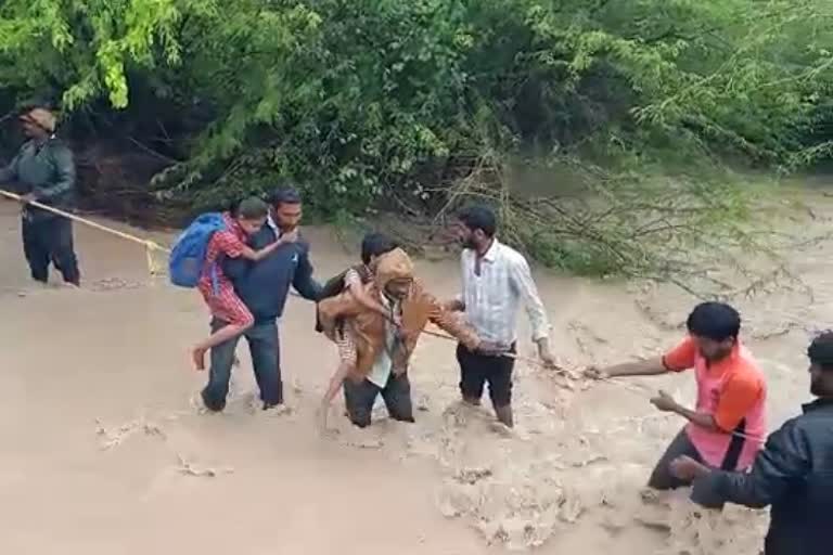 School children and farmers crossed the ditch holding a rope