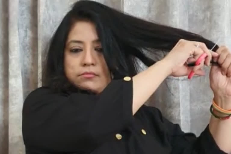 महिला ने बाल काटकर जताया विरोध