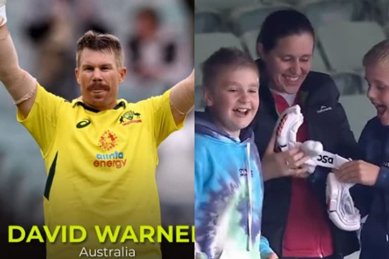 David Warner gives his pair of gloves to a child