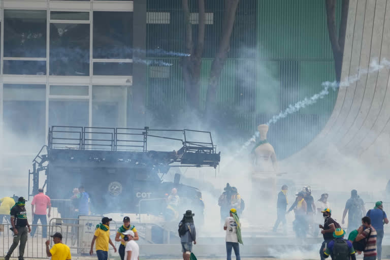 Protesters, supporters of Brazil's former President Jair Bolsonaro, clash with the police after they stormed the Planalto Palace in Brasilia, Brazil, Sunday, Jan. 8, 2023. Planalto is the official workplace of the president of Brazil. (AP Photo/Eraldo Peres)
