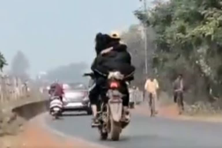 Couple hugging on bike in public glare