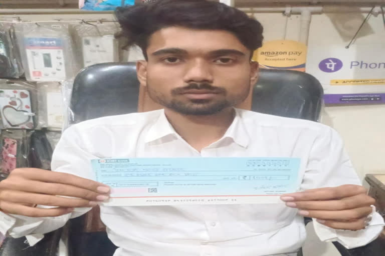 Bihar's protesting youth Aryan Chauhan showing the cheque in Sheohar