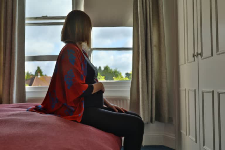 pregnant girl sitting on bed