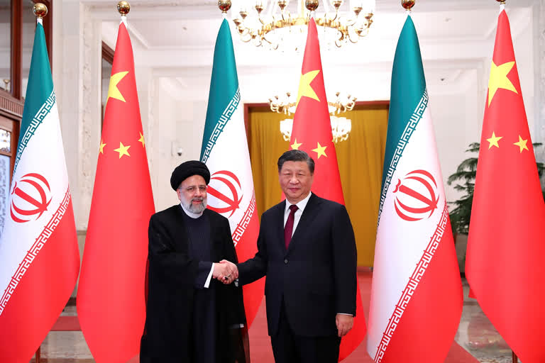 In this photo released by the official website of the office of the Iranian Presidency, President Ebrahim Raisi, left, shakes hands with his Chinese counterpart Xi Jinping in an official welcoming ceremony in Beijing, Tuesday, Feb. 14, 2023. (Iranian Presidency Office via AP)