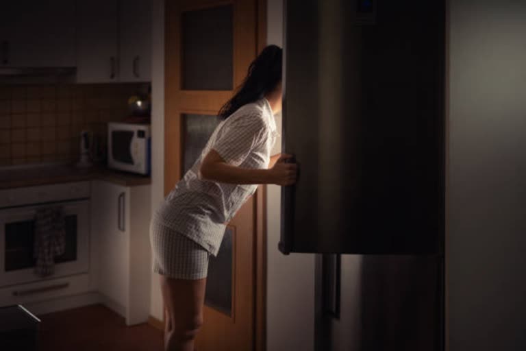 an woman searching food in fridge