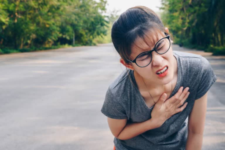 an woman feeling heart problem at street