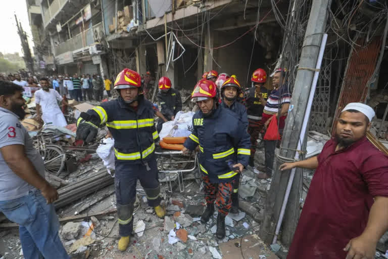 Fire officials carry a body of a victim after an explosion in Dhaka