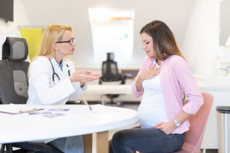 pregnant woman consulting with doctor