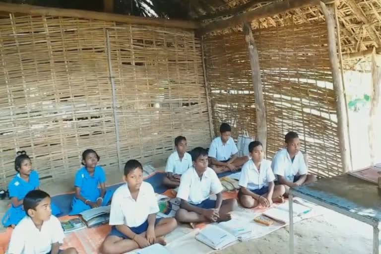 School children studying under tree leaves and soil walls on roof