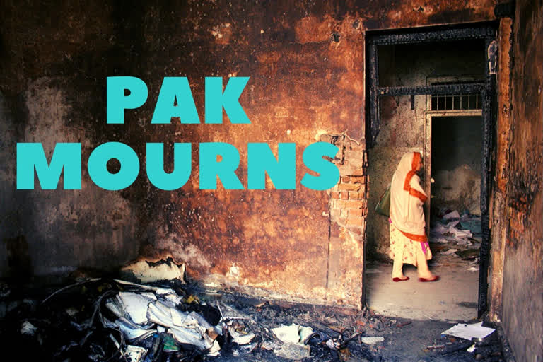 Pakistani woman walks past a burnt classroom at the site of the militants' attack on the army-run school in northwest Pakistan's Peshawar