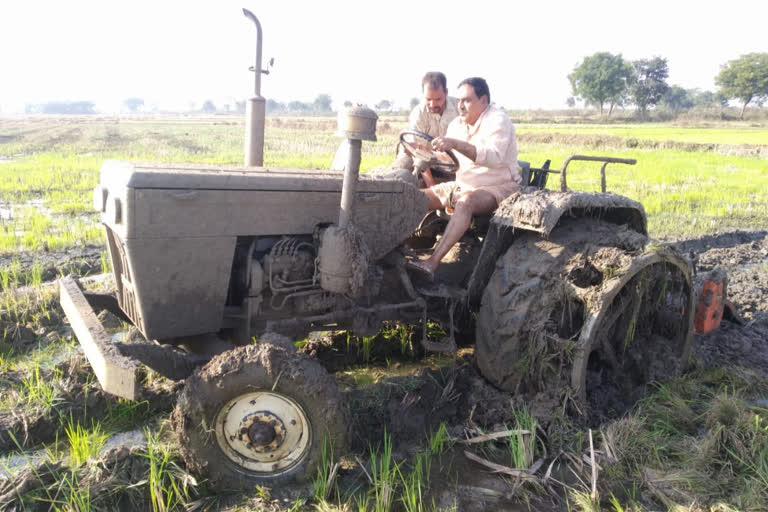 Minister Erbabelli Dayakar Rao on the farm with a tractor in warangal rural district