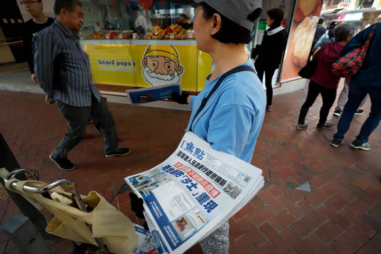 A vendor gives out copies of newspaper with a headlines of "Wuhan break out a new type of coronavirus, Hong Kong prevent SARS repeat" at a street in Hong Kong,