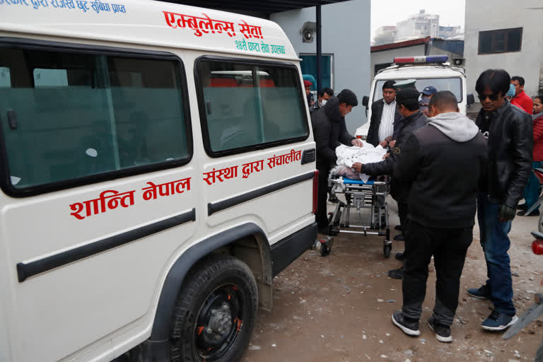 Hospital staff load bodies of Indian tourists into an ambulance for postmortem, at a hospital in Kathmandu, Nepal