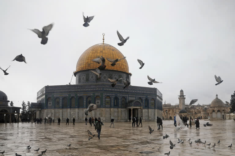 Palestinians walk next to the Dome of the Rock Mosque in the Al Aqsa Mosque compound in Jerusalem's old city, Friday, Feb. 7, 2020.