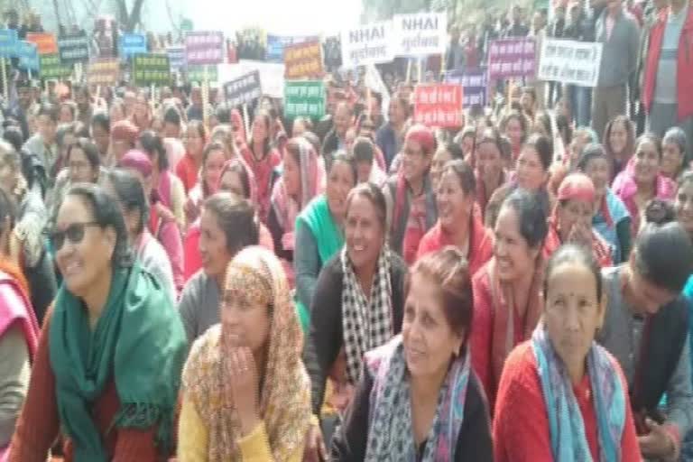 People sit on the streets to protest the toll plaza