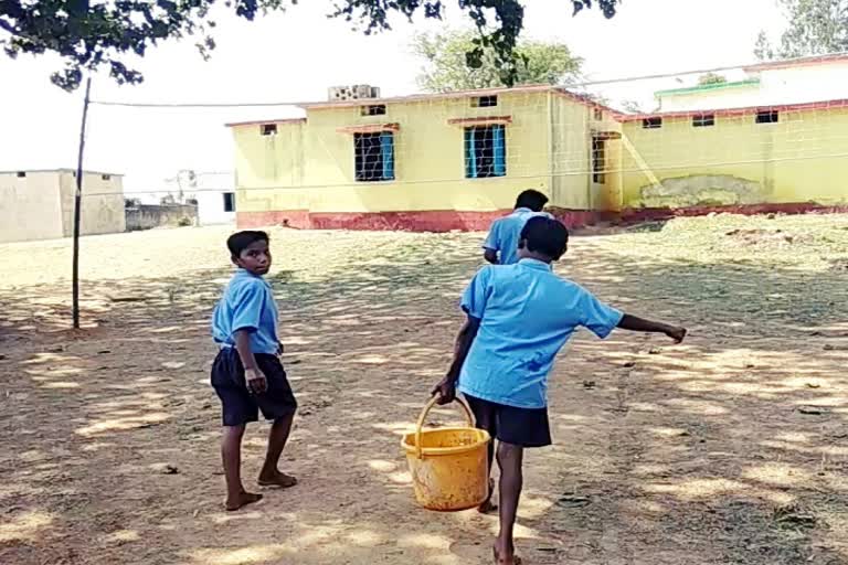 school children filling a bucket of water