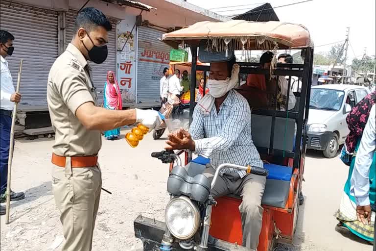 Police giving sanitizer in hand of people