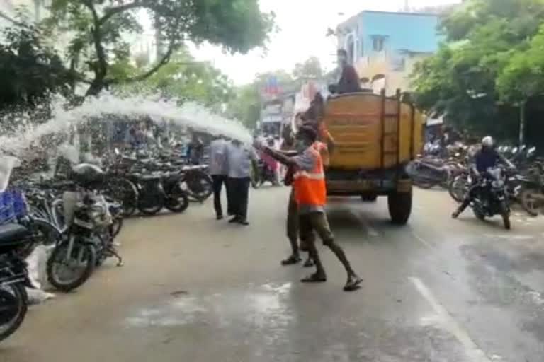 government staffs disinfectant spraying to people