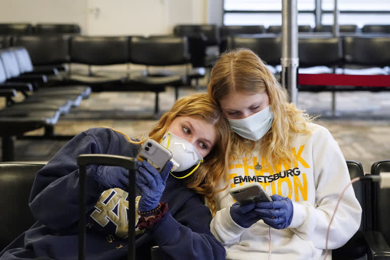 Rachel Miner, 15, left, of Emmetsburg, Iowa, sits with Carlotta Haas, 15, a foreign exchange student from Duesseldorf, Germany, who had been living with Miner and her family but was called home, as they waited for her flight