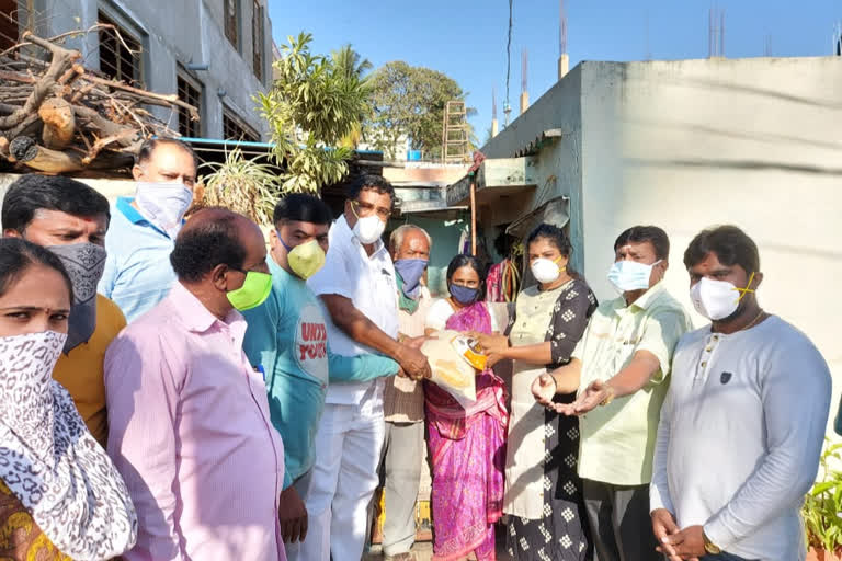 Corporator distributing groceries to poor people on their way home