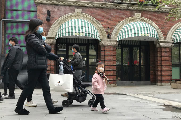 Residents wearing masks visit a shopping street in Wuhan in central China's Hubei province