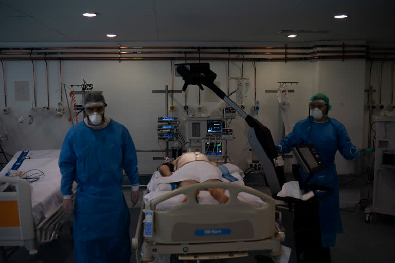 Healthcare workers prepare to x-ray a COVID-19 patient at a library that was turned into an intensive care unit