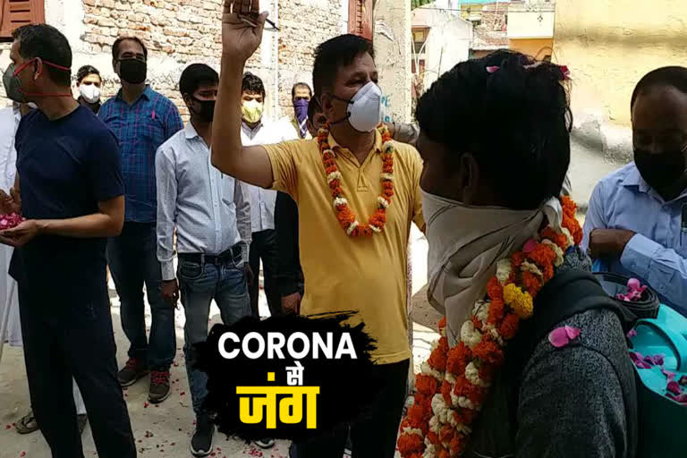 Corona warriors welcome with garlands at Pradhan Enclave in Burari