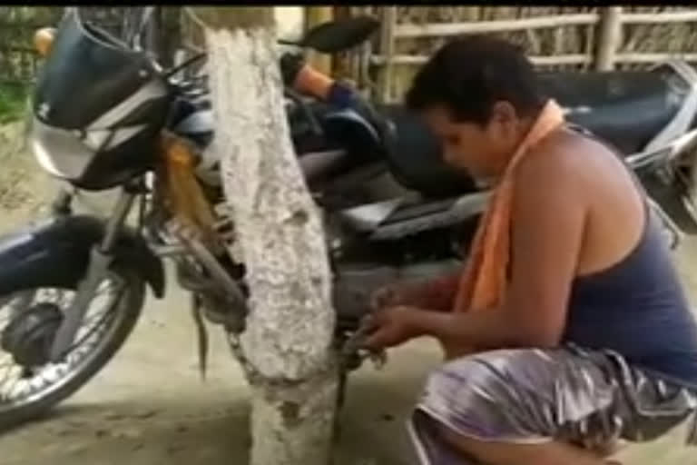 Father Prakash Mandal tied the motorcycle with an iron chain and hanged it on a mango tree