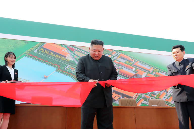 North Korean leader Kim Jong Un, center, cuts a tape, watched by his sister Kim Yo Jong, during his visit to a fertilizer factory in Sunchon, South Pyongan province