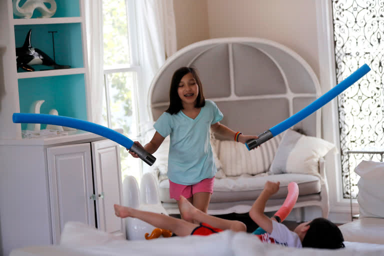 Juliet Daly, 12, plays with her brother Dominic, 5, in their family home in Covington, La.