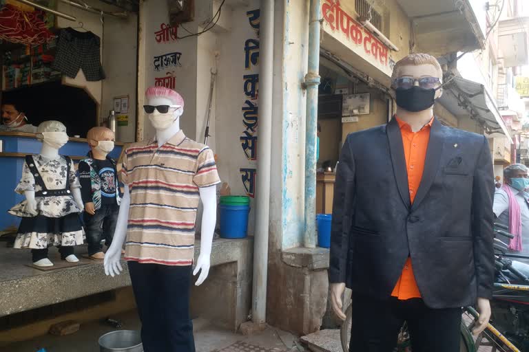 businessman-awaring-people-by-applying-mask-to-mannequins-in-dhamtari