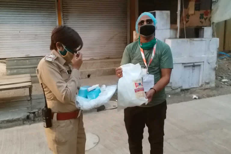 social-worker-is-providing-sanitizer-mask-and-ppe-kit-to-the-police-in-indore