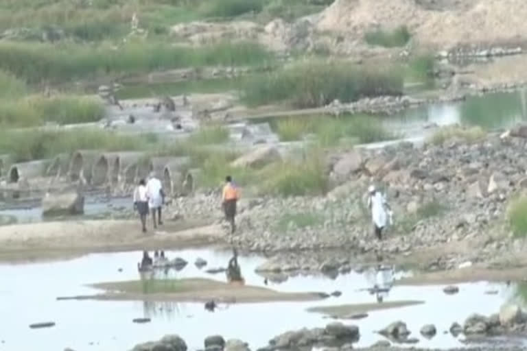 ನದಿ ದಾಟಿಕೊಂಡು ಬರುತ್ತಿರುವ ಜನ