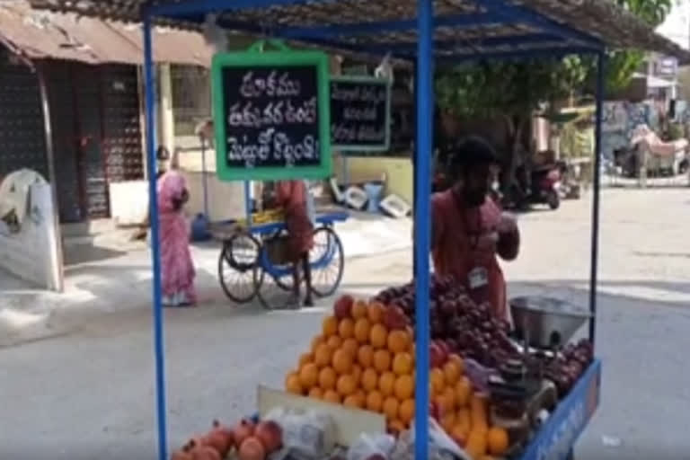 a frutis seller wrote on a slate to create awareness on corona at the same time about his bussiness selling