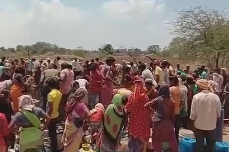 peoples gather at well for water