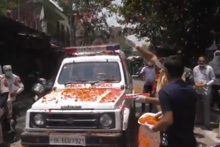 people shower flowers on policemen at gamdi road