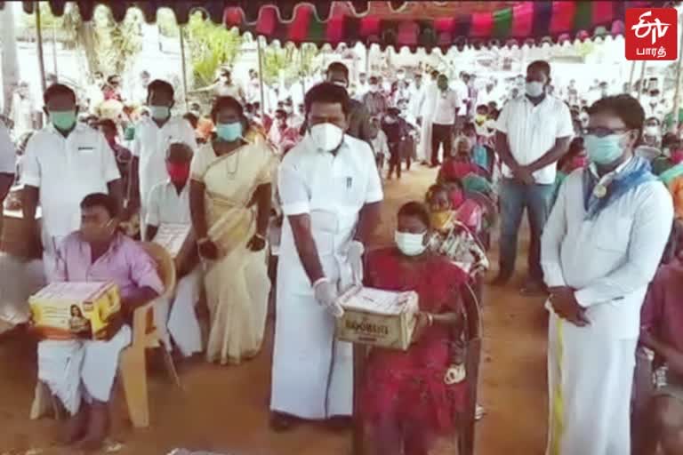 அமைச்சர் காமராஜ் ஒருவருக்கு நிவாரண உதவி வழங்கும் காட்சி