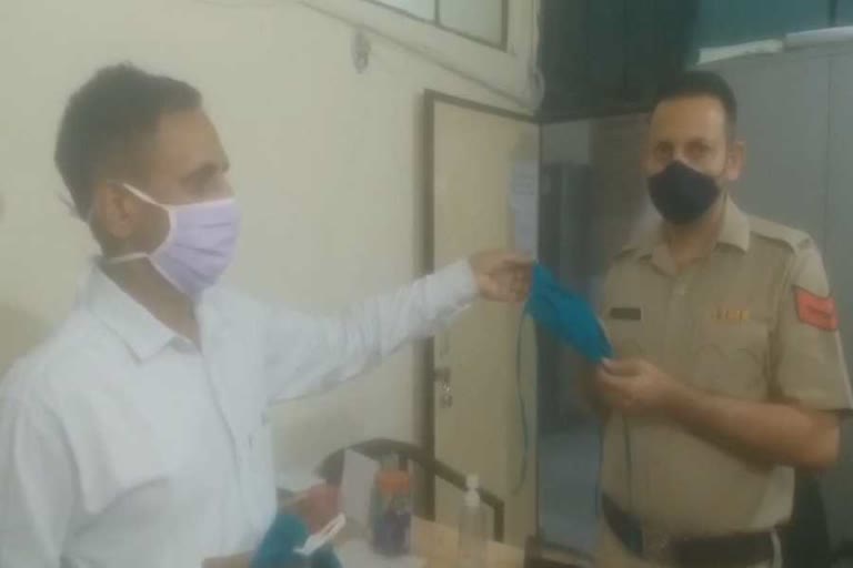 water carrier employee serving needy by giving mask in panchkula