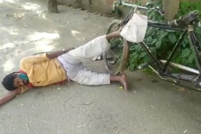 Rickshaw driver lying on the road in scorching heat in Ghaziabad