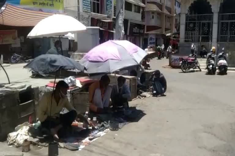 Cobbler sitting in the shade due to strong sunlight