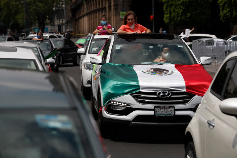 People participate in a caravan of cars protest calling for Mexican President Andres Manuel Lopez Obrador to step down, in front of the National Palace in Mexico City, on Saturday.