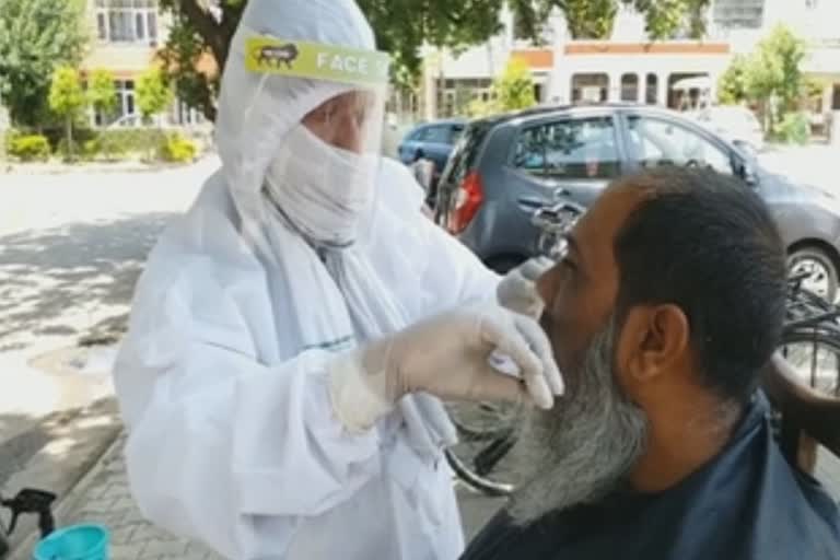 The barber is also doing the work by putting PPE kit