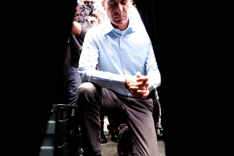 Joined by community faith leaders Los Angeles Mayor Eric Garcetti takes a knee in prayer during a Black Lives Matter protest in downtown Los Angeles, on Tuesday.