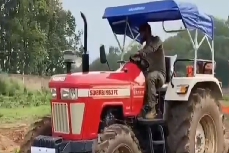 Dhoni driving a tractor in the fields