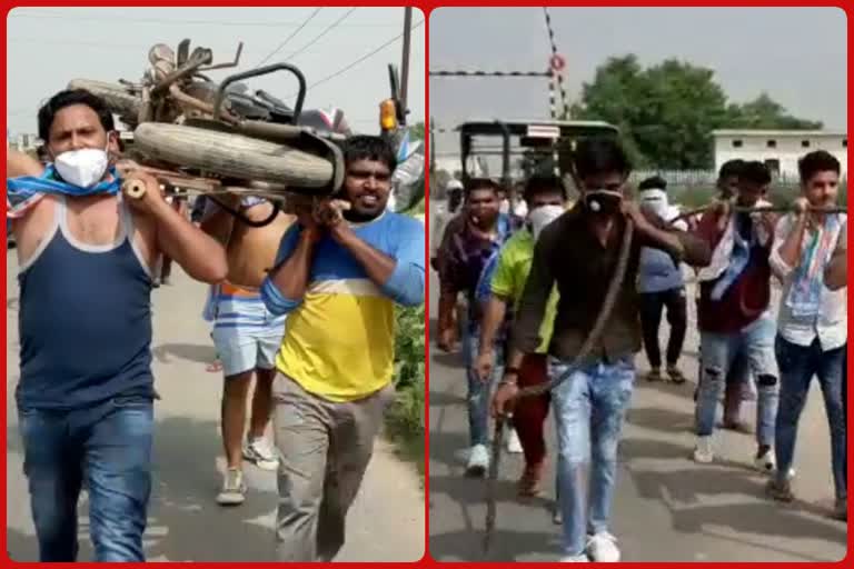 NSUI protests by putting motorcycle on the bier and pulling the tractor with rope