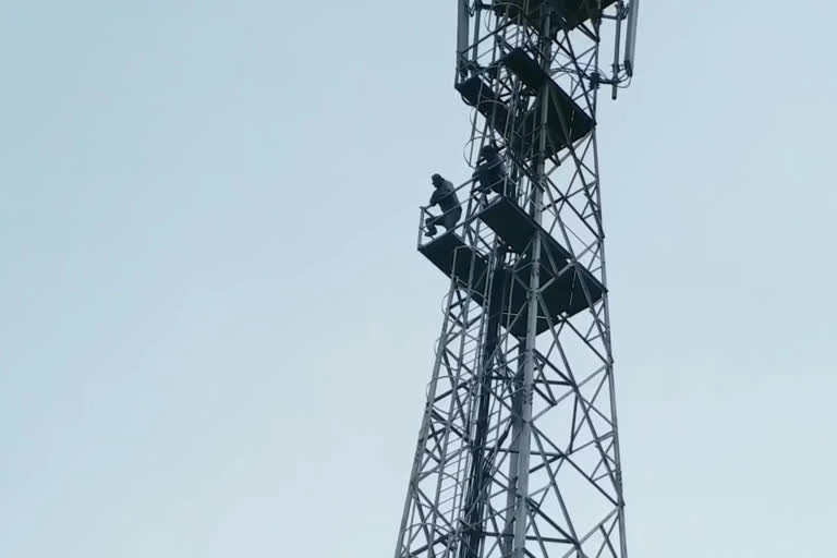 two young men climbing the cell tower at peravali west godavari district